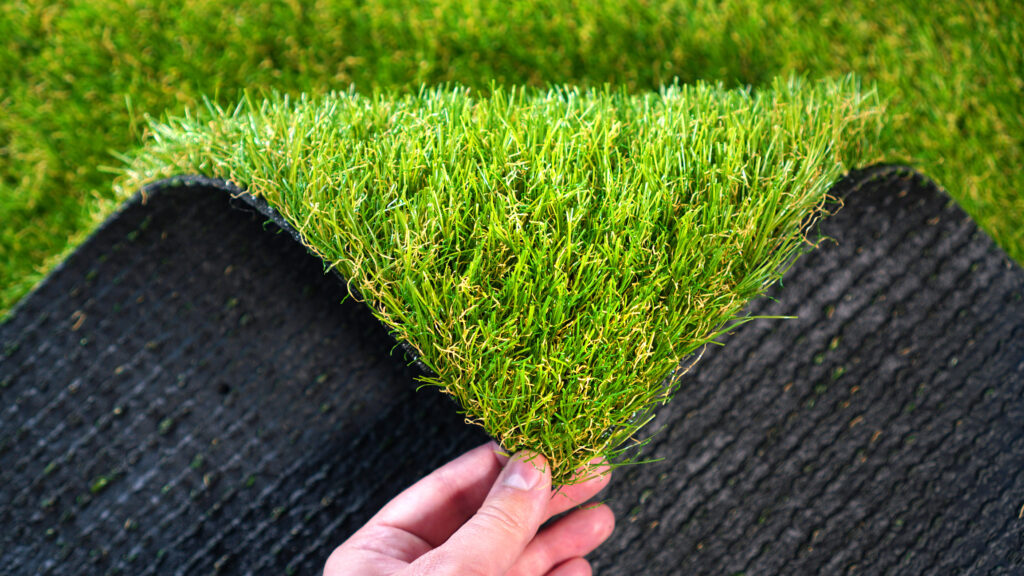 Hand holding an artificial grass